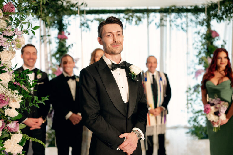 groom in tuxedo and groomsmen behind him